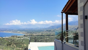 A balcony with a pool and a view of a coastal landscape. - Villa ArGia with private pool & sea view (Apokoronas)