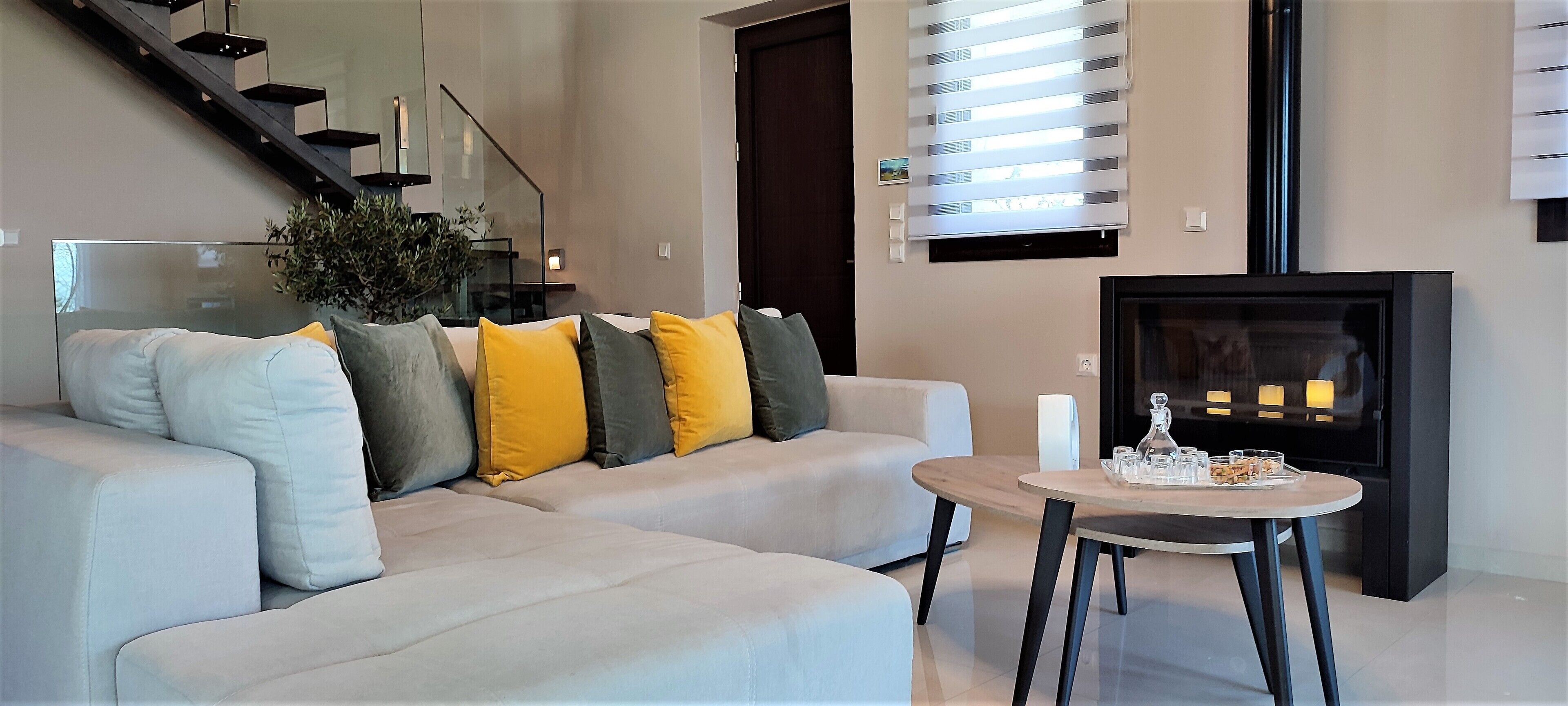 A modern living room with a sofa, a small round table, and a fireplace.