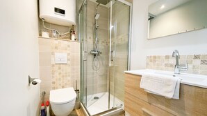 A modern bathroom with a glass-enclosed shower, a toilet, and a vanity with a mirror. - #GB | Au Coeur de l'Essentiel 2 🈴 (Saint-Martin-le-Vinoux)