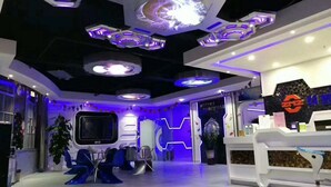 A modern interior with a central seating area, a reception desk, and a large screen. - Zhuhai Dreamers Capsule Hotel (Zhuhai)