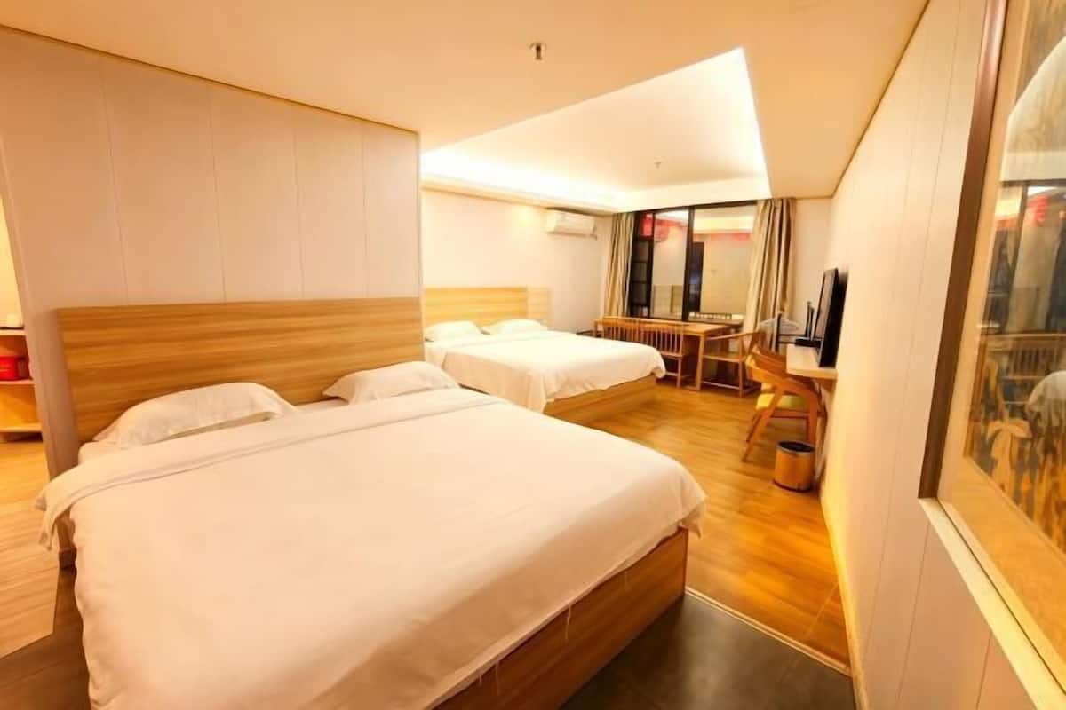 Ett hotellrum med två sängar, ett skrivbord och en stol.