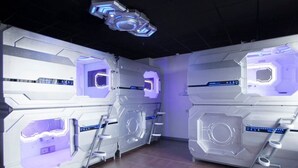 A futuristic room with hexagonal walls and a central control panel. - Zhuhai Dreamers Capsule Hotel (Zhuhai)