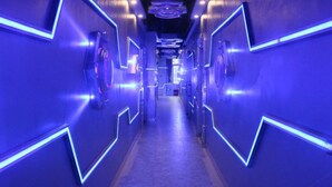 A hallway with a futuristic design, featuring geometric patterns and blue lighting. - Zhuhai Dreamers Capsule Hotel (Zhuhai)
