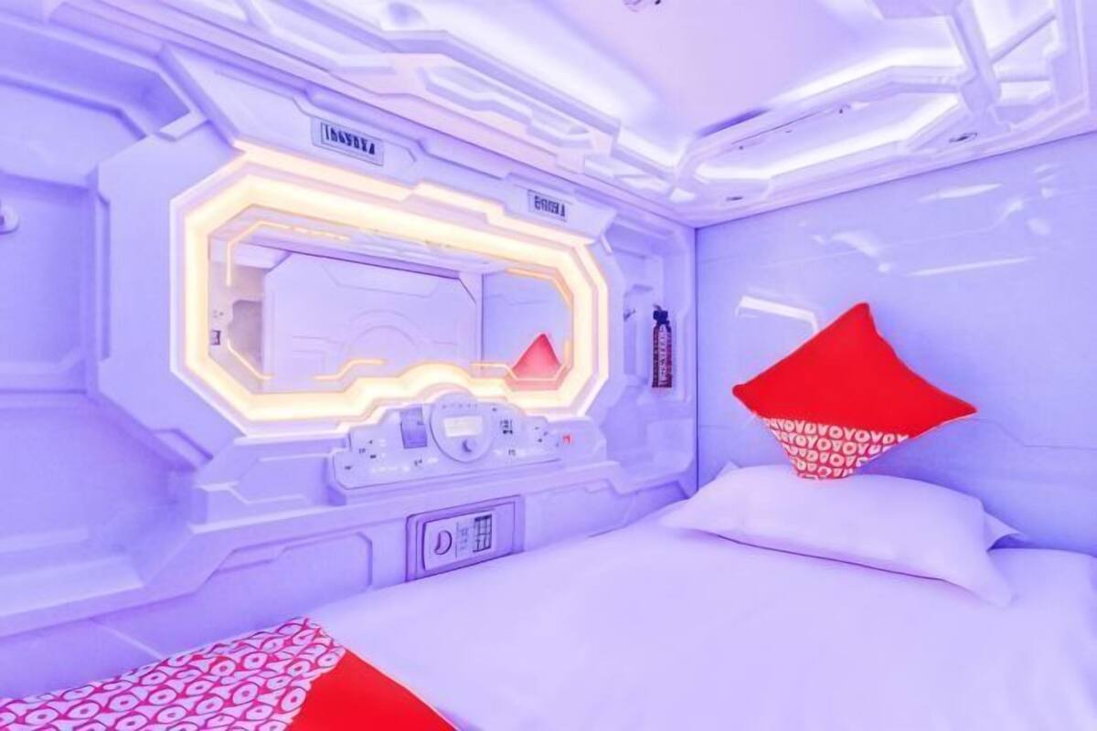 Une piĂšce futuriste avec un lit, un panneau de contrĂŽle et un miroir.