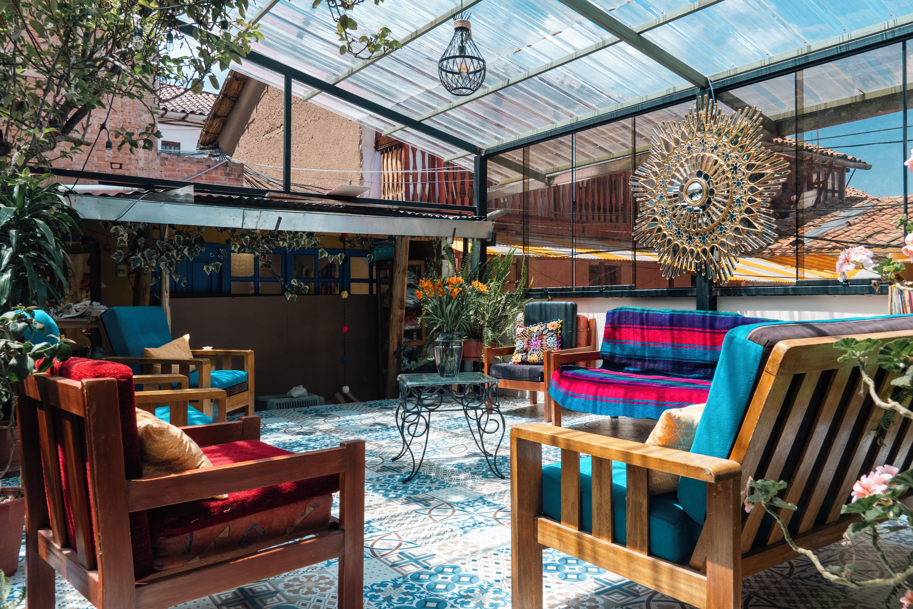 Un espacio interior amplio con techo alto, mobiliario de madera y una variedad de plantas.