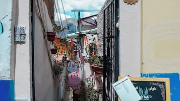 A narrow alleyway leading to a building with a sign reading 'La Casa de Carmen Hospedaje Familiar.'