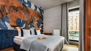 A modern hotel room with a large bed, a city view, and a unique tiger mural on the wall. - Brabank Residence by HappyStay (Gdansk)