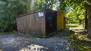 Een houten hutje met een grindpad en een bordje dat aangeeft dat het een vakantiehuis is.