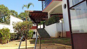 A pool area with a clear view of a house with a balcony and stairs leading to the entrance. - Amplo estudio proximo ao BOS em Sorocaba (Sorocaba)