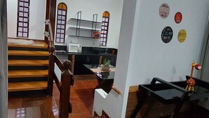 A spacious living area with a staircase, a kitchen, and a dining area. - Amplo estudio proximo ao BOS em Sorocaba (Sorocaba)