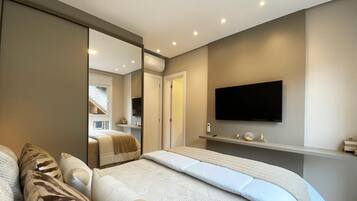 Un dormitorio con una cama, un televisor montado en la pared y un armario con puertas correderas.