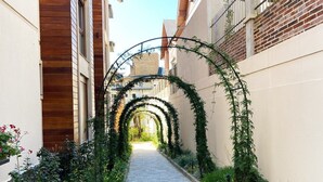 Un vialetto stretto con un percorso in mattoni, affiancato da edifici con facciate in legno e mattoni.
