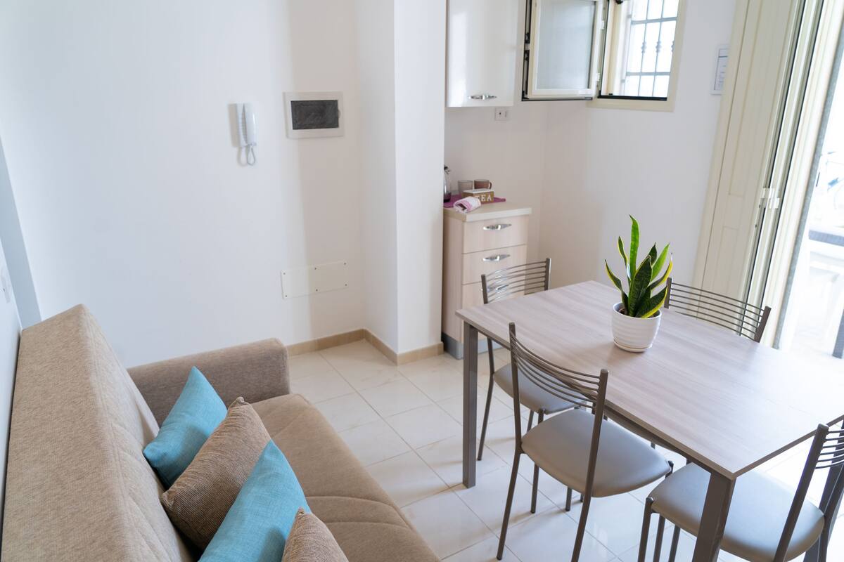 Ein modernes Wohnzimmer mit einer Couch, einem Esstisch und Stühlen.