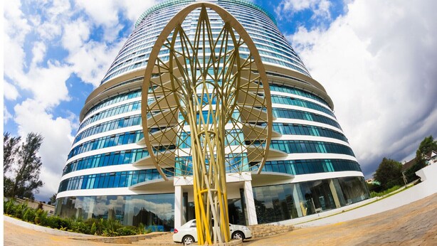 A modern building with a circular design and a large golden sculpture in front. - Lux Suites Le marc Luxury Apartments (Nairobi)