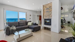 Een moderne woonkamer met een bank, een glazen salontafel en een open haard.