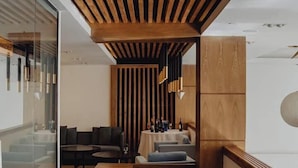Un interior moderno con techo de madera, una zona de estar con mesa y una barra.