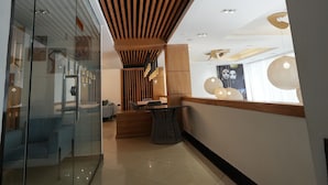 Un interior moderno con techo inclinado, paredes de vidrio y una zona de recepción.