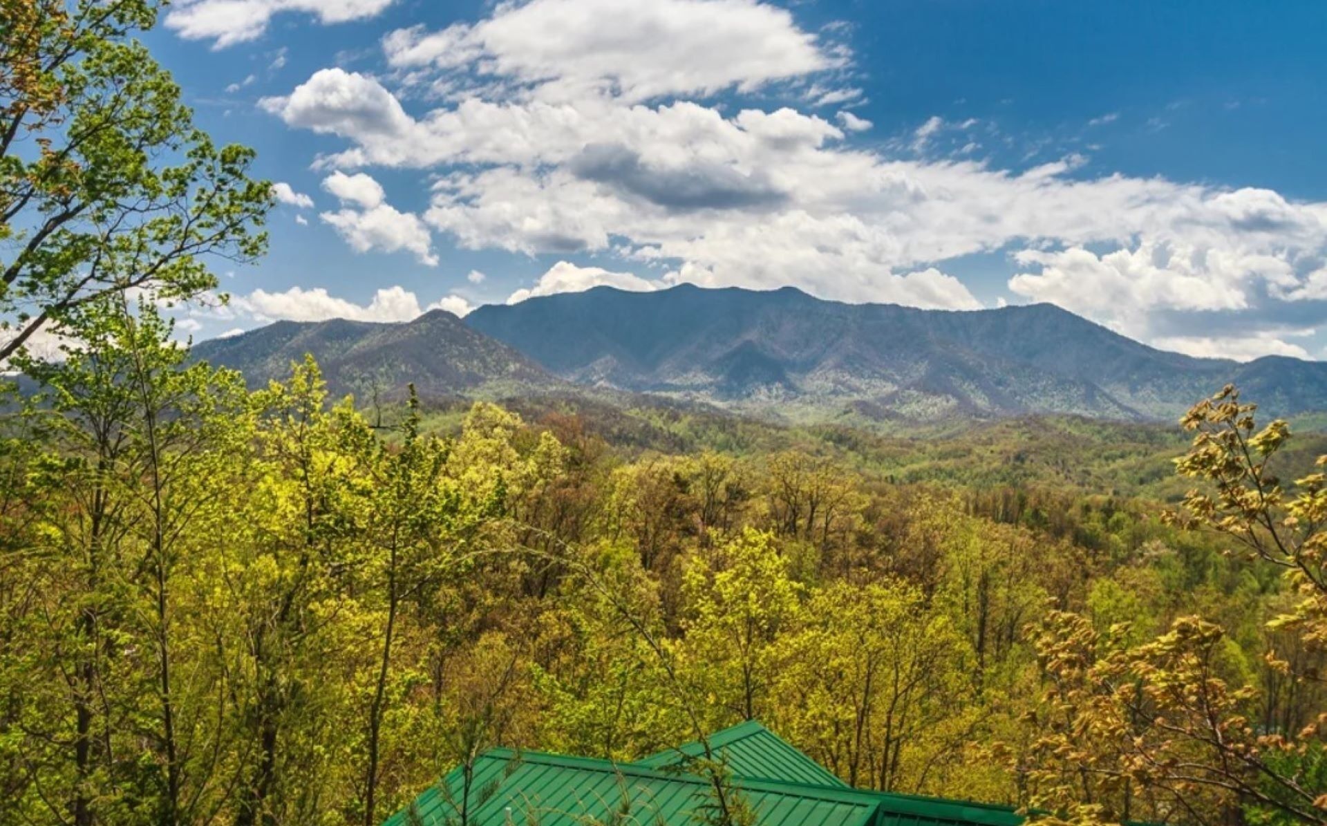 A mountainous landscape with a green-roofed building in the foreground.