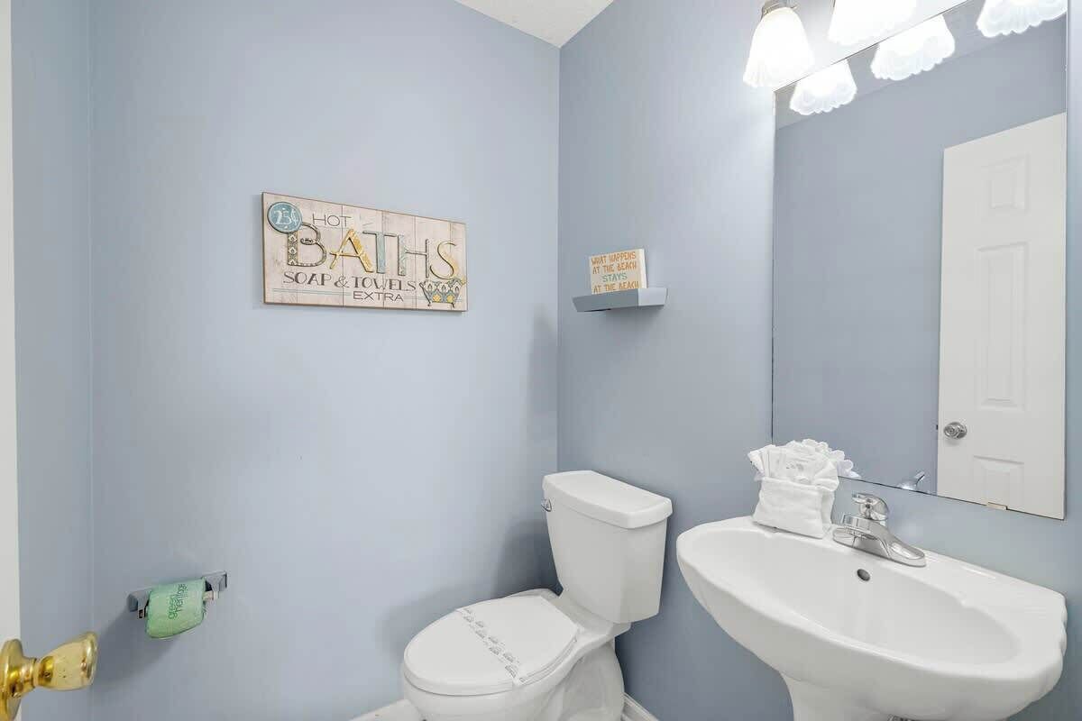 Un baño con inodoro, lavamanos y dos luces empotradas.