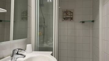 Een douche, handdoeken, toiletpapier