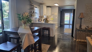 A modern kitchen with a central island, dark wooden furniture, and a view to the outdoors.