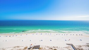 A beach with a clear sky, a sandy shore, and a wooden walkway leading to a structure. - Phoenix Gulf Towers 1701  Gulf-Front 4BR Condo (Orange Beach)