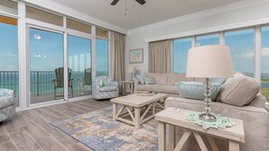 Un vaste balcon offrant une vue sur l’océan, aménagé avec un canapé, des fauteuils et une table basse.