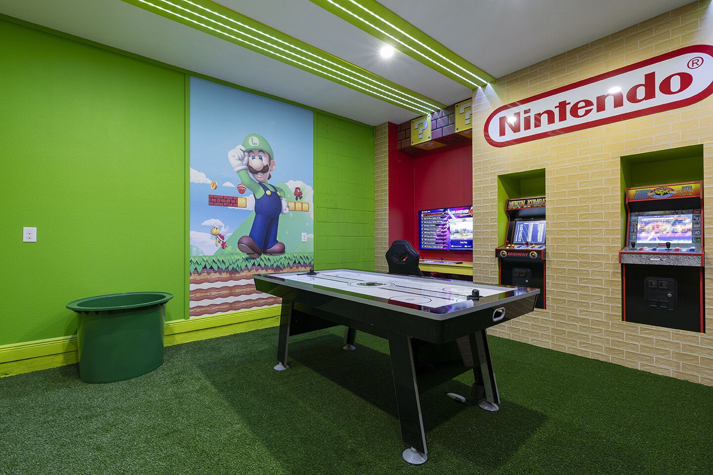 A Nintendo-themed room with a foosball table, green walls, and arcade games.
