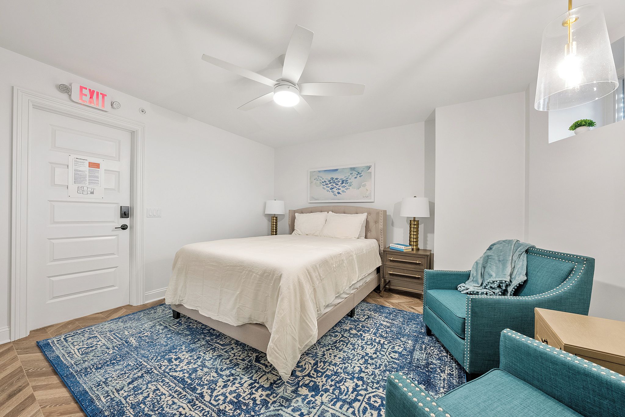 Unwind in your bright, airy bedroom with plush bedding, a cozy sitting area, and modern touches like a sleek ceiling fan and elegant lighting to help you feel right at home.