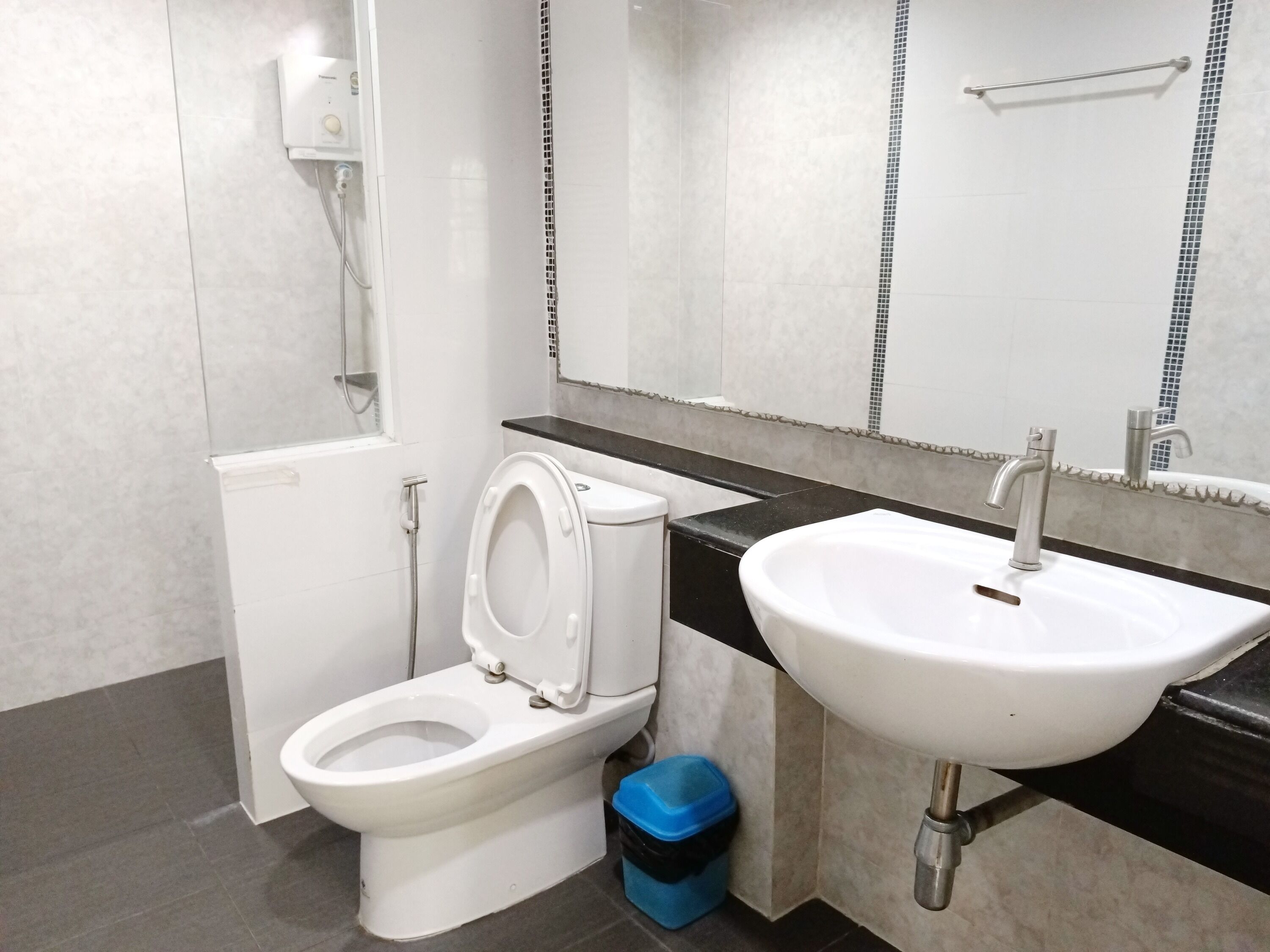 Een moderne badkamer met toilet, wastafel en douche.