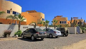 A parking area with several cars, including a white sedan and a dark-colored SUV. - 8AP Beautiful 1st Floor Condo, Pool Side, Cerritos
 (El Pescadero)