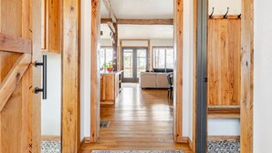 Een houten interieur met een keukenhoek, een woonkamer met een bank en een eethoek.