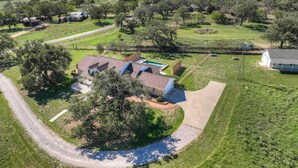 A large house with a spacious backyard, a swimming pool, and a well-maintained lawn.