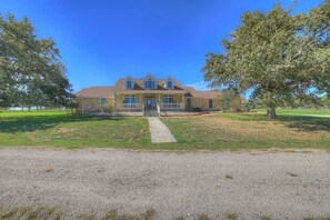 A two-story house with a front porch, a driveway, and a lawn.