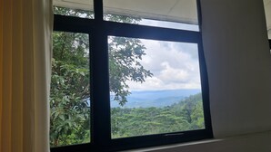 A window with a view of a lush green landscape and mountains. - 20 min walk to Kandy city from this breezy, quite property with a parking. (Kandy)