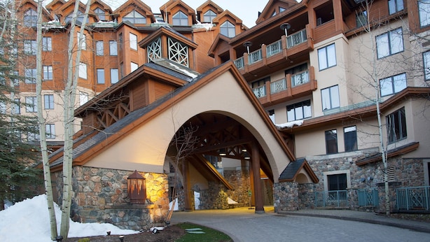 A multi-story building with a stone facade, wooden balconies, and a central archway entrance. - Mccoy Peak Lodge #107 1 Bedroom Condo by RedAwning (Avon)
