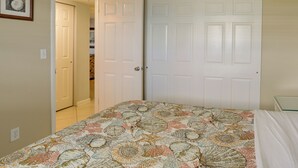 A bedroom with a bed, a closet, and a door leading to another room. - Sandy Shores Condo Across From Johns Pass! (Madeira Beach)