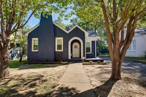 A two-story house with a dark blue exterior, a front door with a white frame, and a small porch.