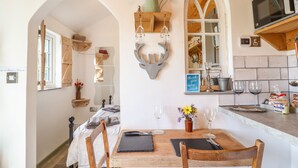 Un'accogliente sala da pranzo con un tavolo in legno, due sedie e uno specchio sopra.