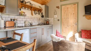 Una cucina accogliente con mobili in legno, forno integrato e zona pranzo con tavolo e sedie.