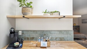 A kitchen with a coffee maker, a basket of toiletries, and a plant on a shelf. - Pet-friendly Kent Vacation Rental, Walk to Lake! (Covington)