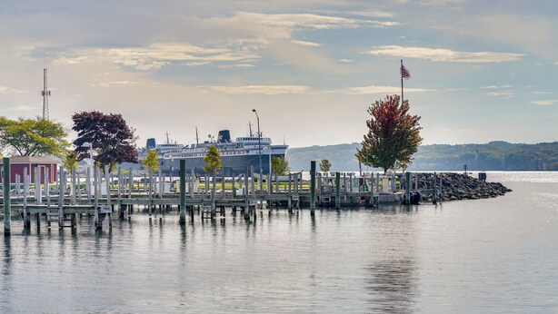 A waterfront dock with a large ship, wooden piers, and a flag. - Ludington Vacation Rental - Walk to Lake Michigan! (Ludington)
