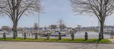 Une vue sur le front de mer, avec un port de plaisance, des bateaux et des arbres le long de la rive.
