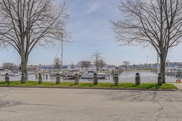 A waterfront view with a marina, boats, and trees along the shore.