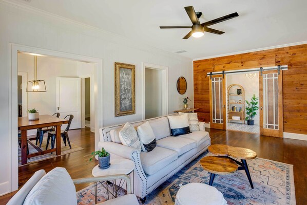 A spacious living room with a white sofa, wooden coffee table, and a ceiling fan. - Walk to Dtwn: 'tyler Tudor' w/ Backyard (Tyler)