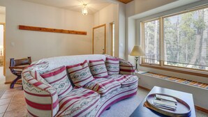 Una sala de estar acogedora con un sofá, una mesa de centro y una ventana con persianas.