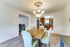 A dining room with a wooden table, six chairs, and a chandelier. - Crescent City Home w/ Hot Tub: Half-block to Beach (Crescent City)