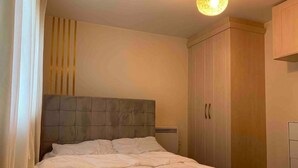 Une chambre à coucher avec un lit, une armoire et un luminaire au plafond.