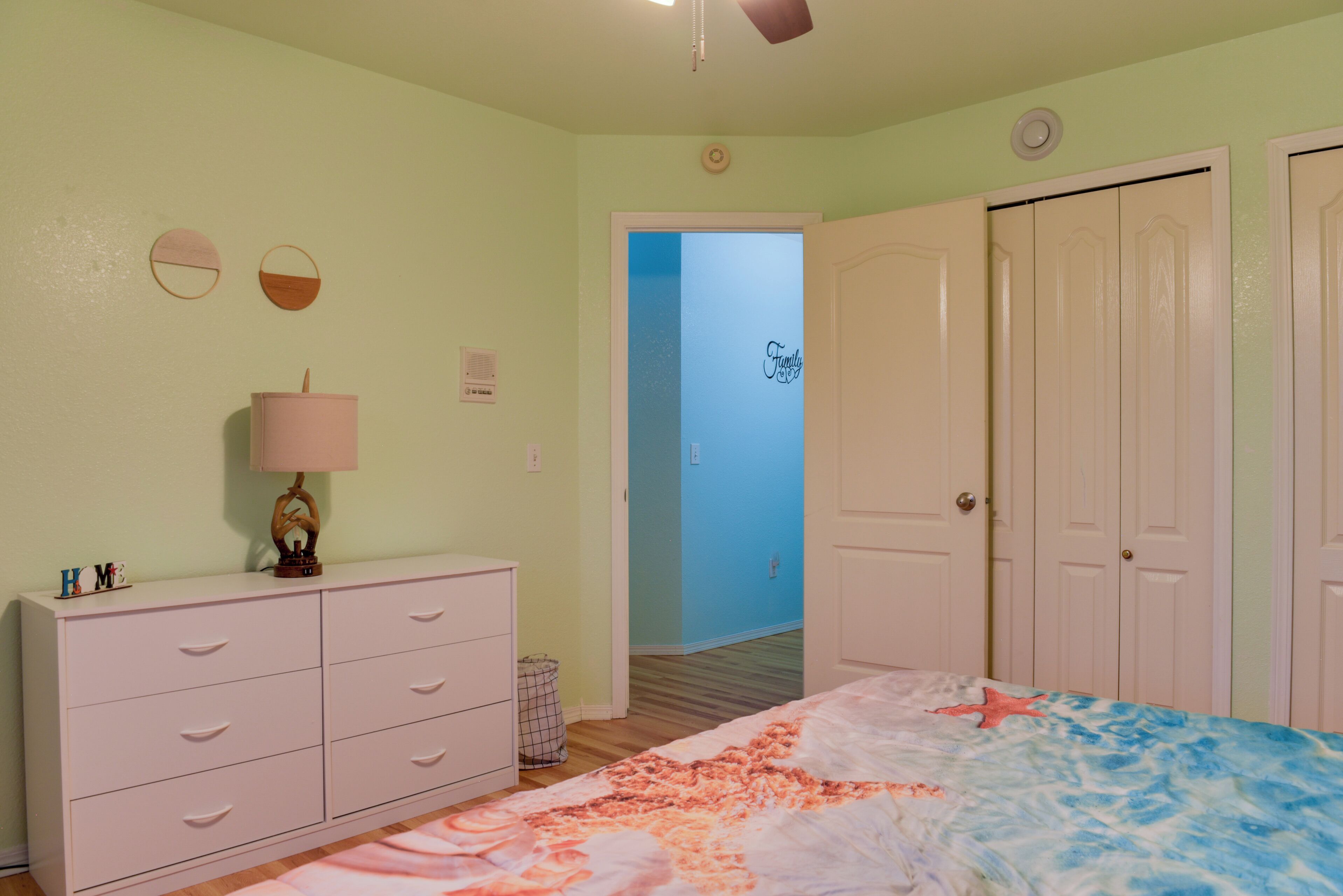 A bedroom with a bed, dresser, and wardrobe.
