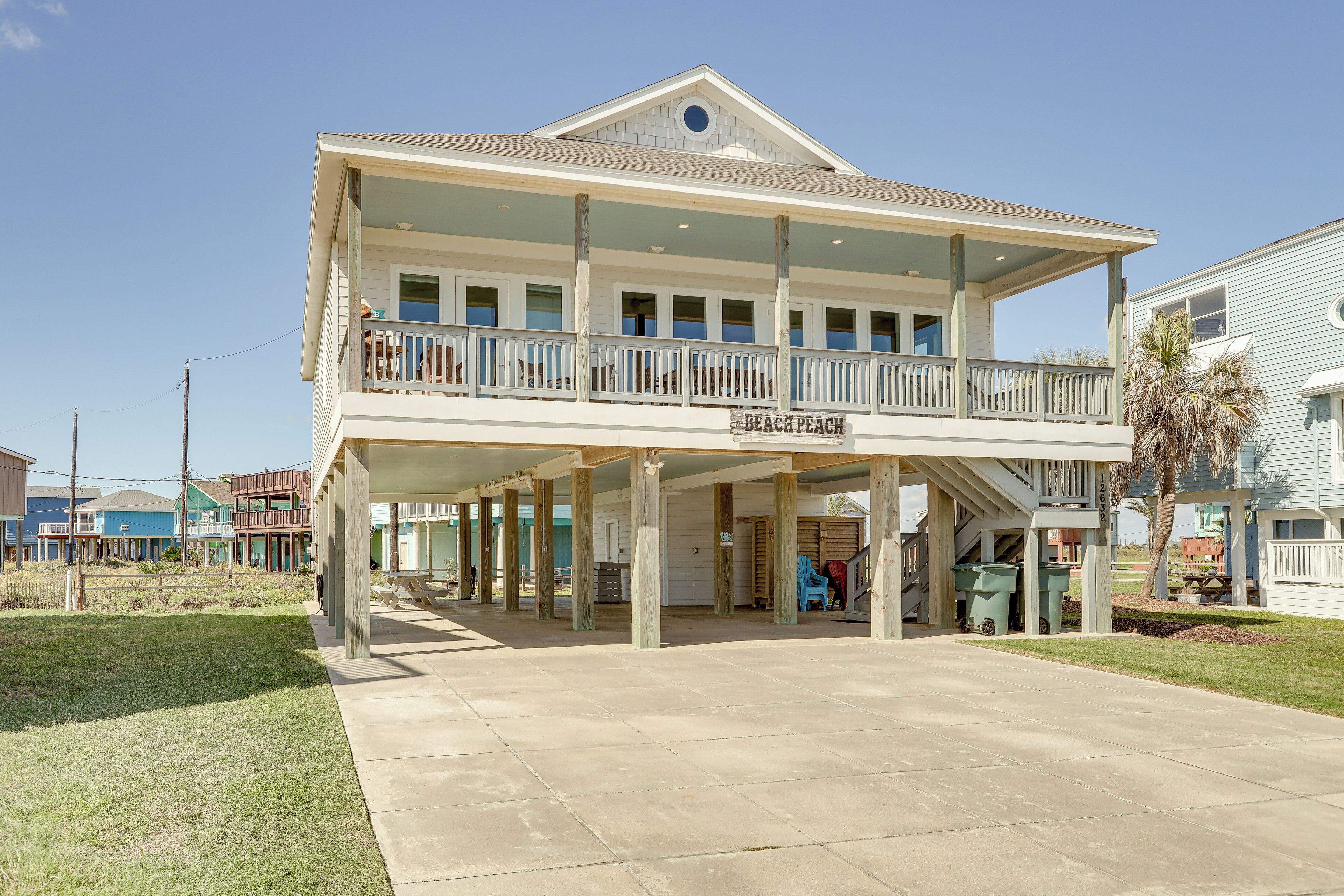 A two-story building with a covered patio area and a sign reading "Beach Peach."